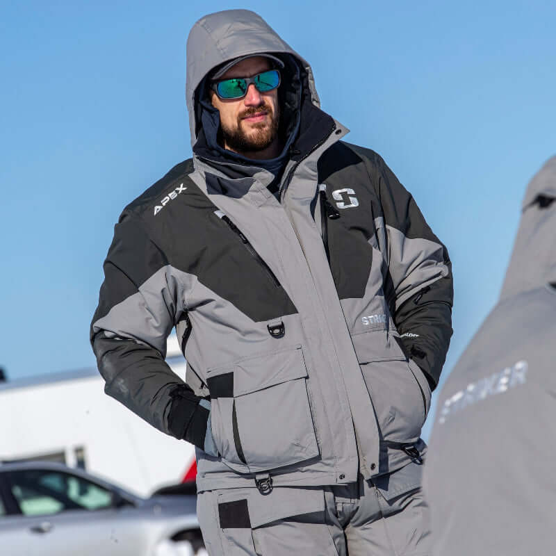 Man wearing a gray and black Apex jacket with sunglasses against a blue sky.