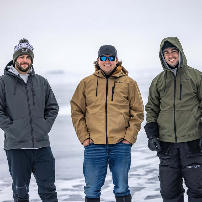 Three men wearing winter jackets standing in a snowy landscape