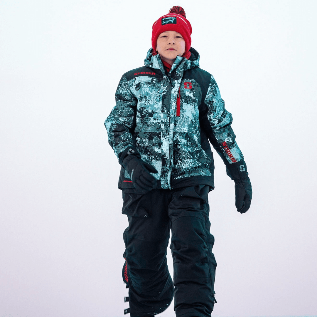 Youth wearing an ice suit walking on frozen lake.